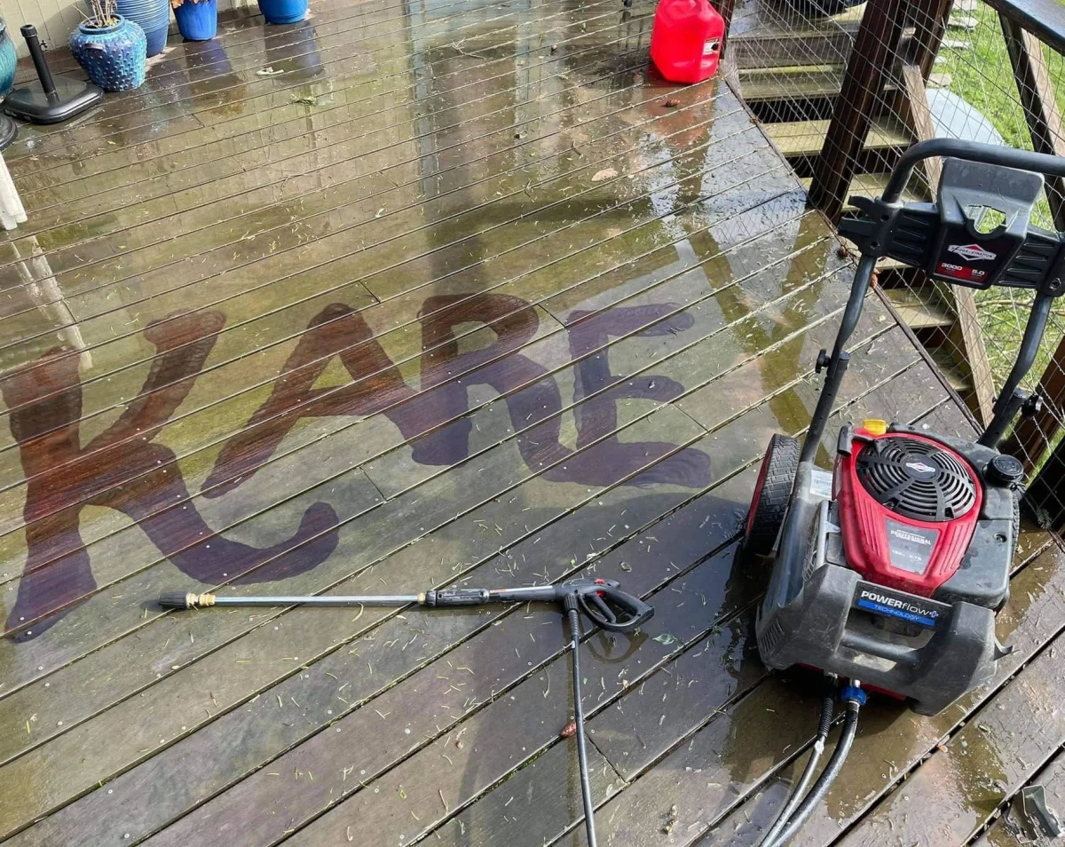 A freshly pressure-washed deck with the Kare name rinsed into the clean wood