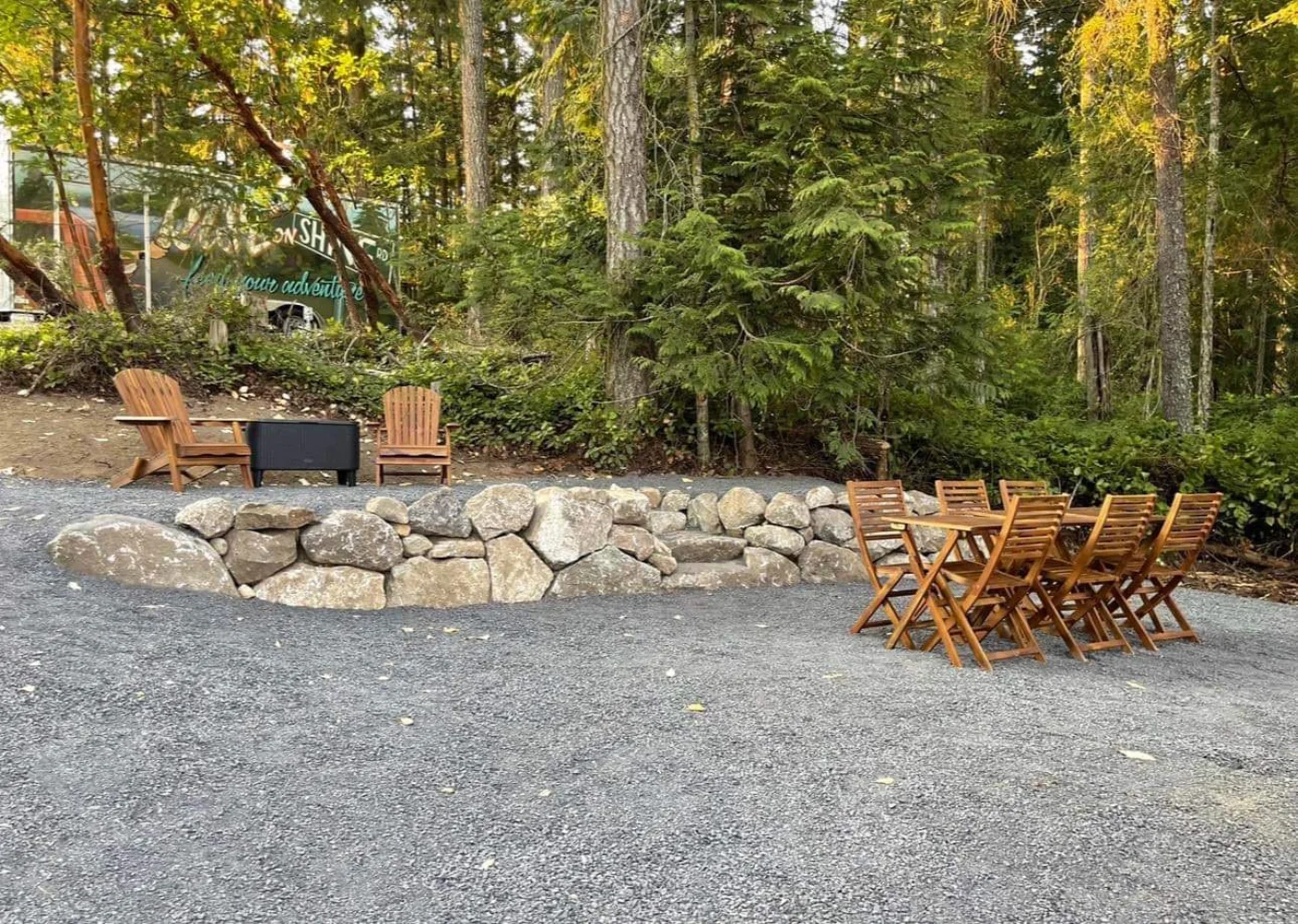 A finished hardscape with a fieldstone retaining wall and fire pit